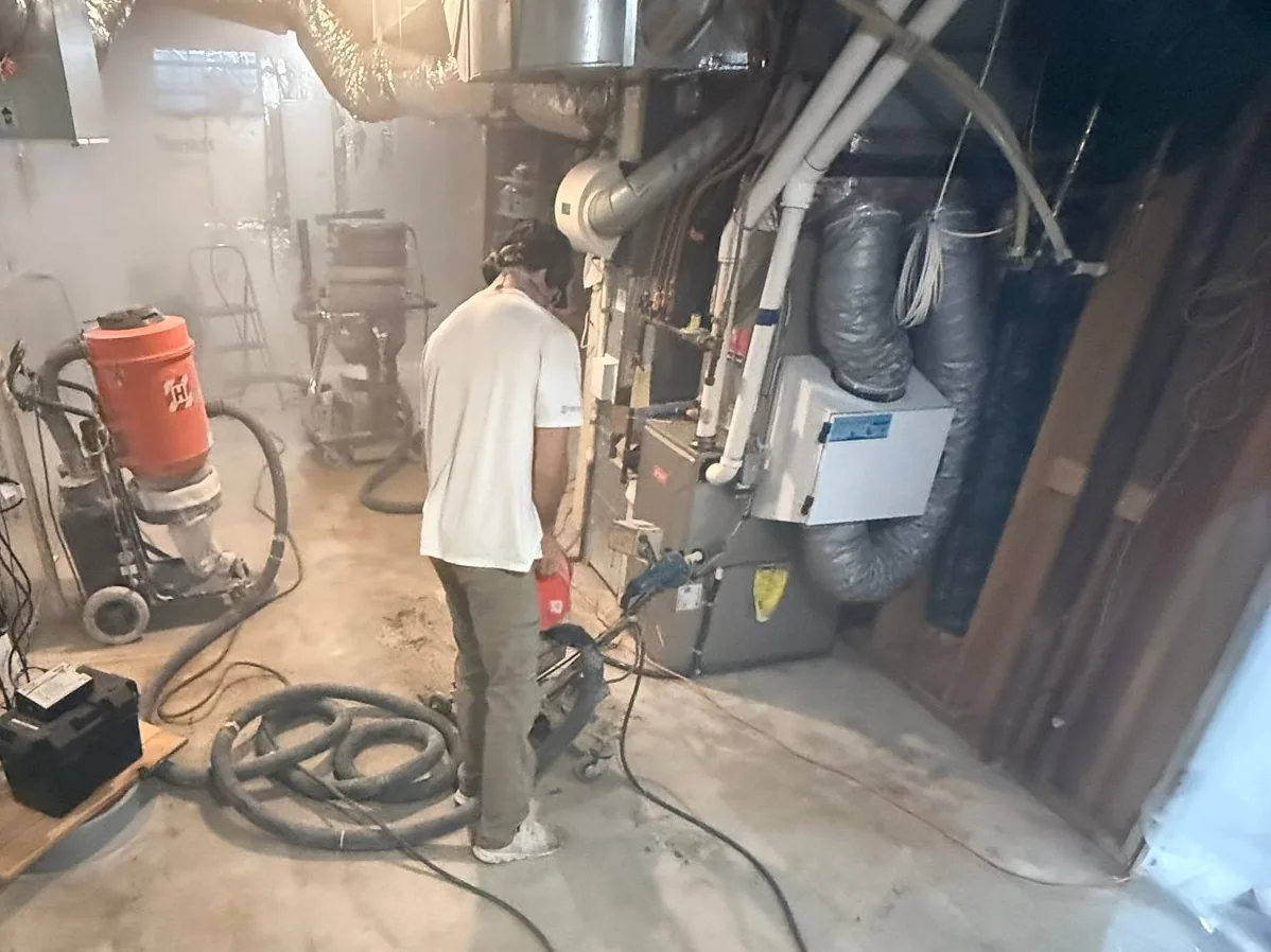 Crew preparing a basement utility room floor for coating