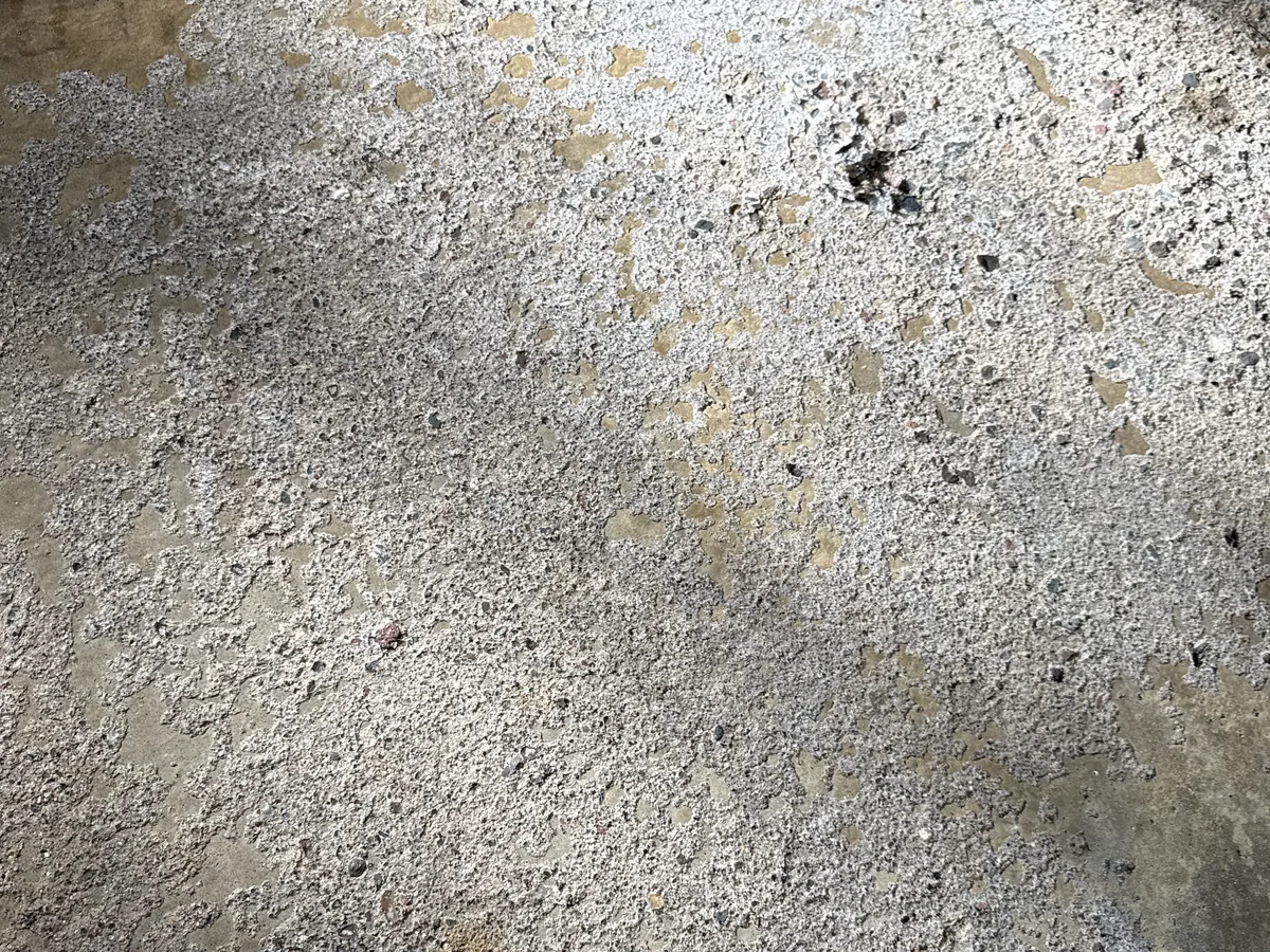 Deep pitting across a concrete garage slab