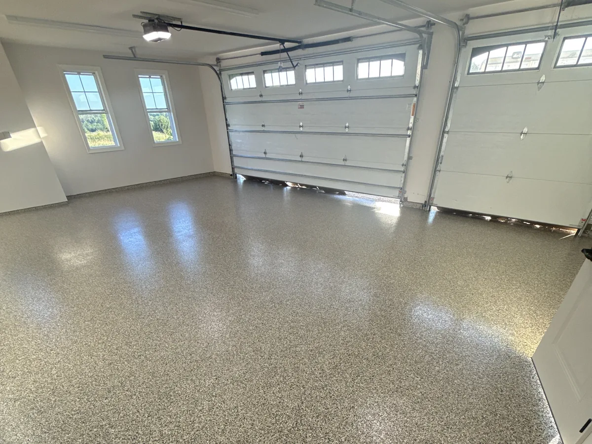 Flake floor coating in a bright garage with two overhead doors