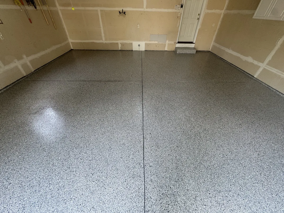 Glossy gray flake garage floor with the control joints showing as clean lines