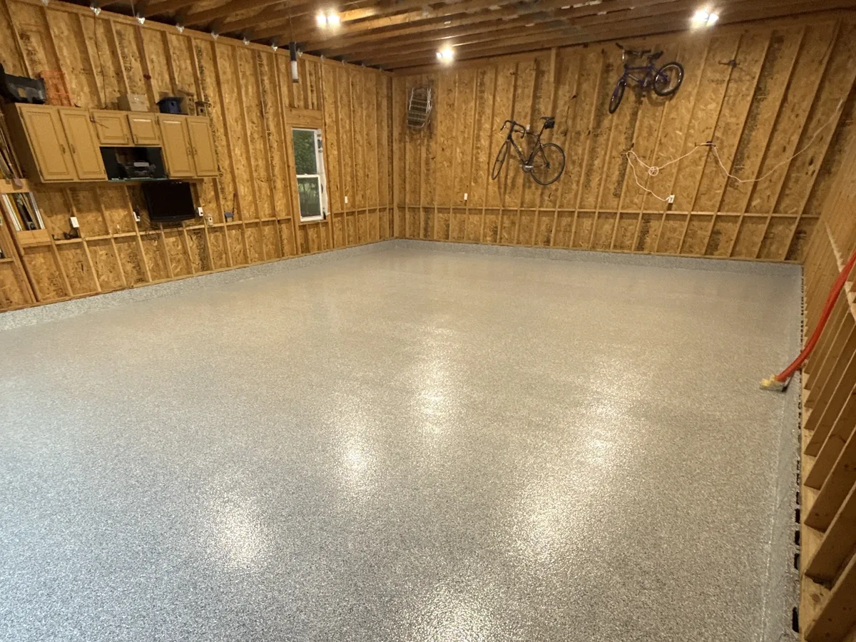 The same wood walled garage with a glossy light gray flake floor