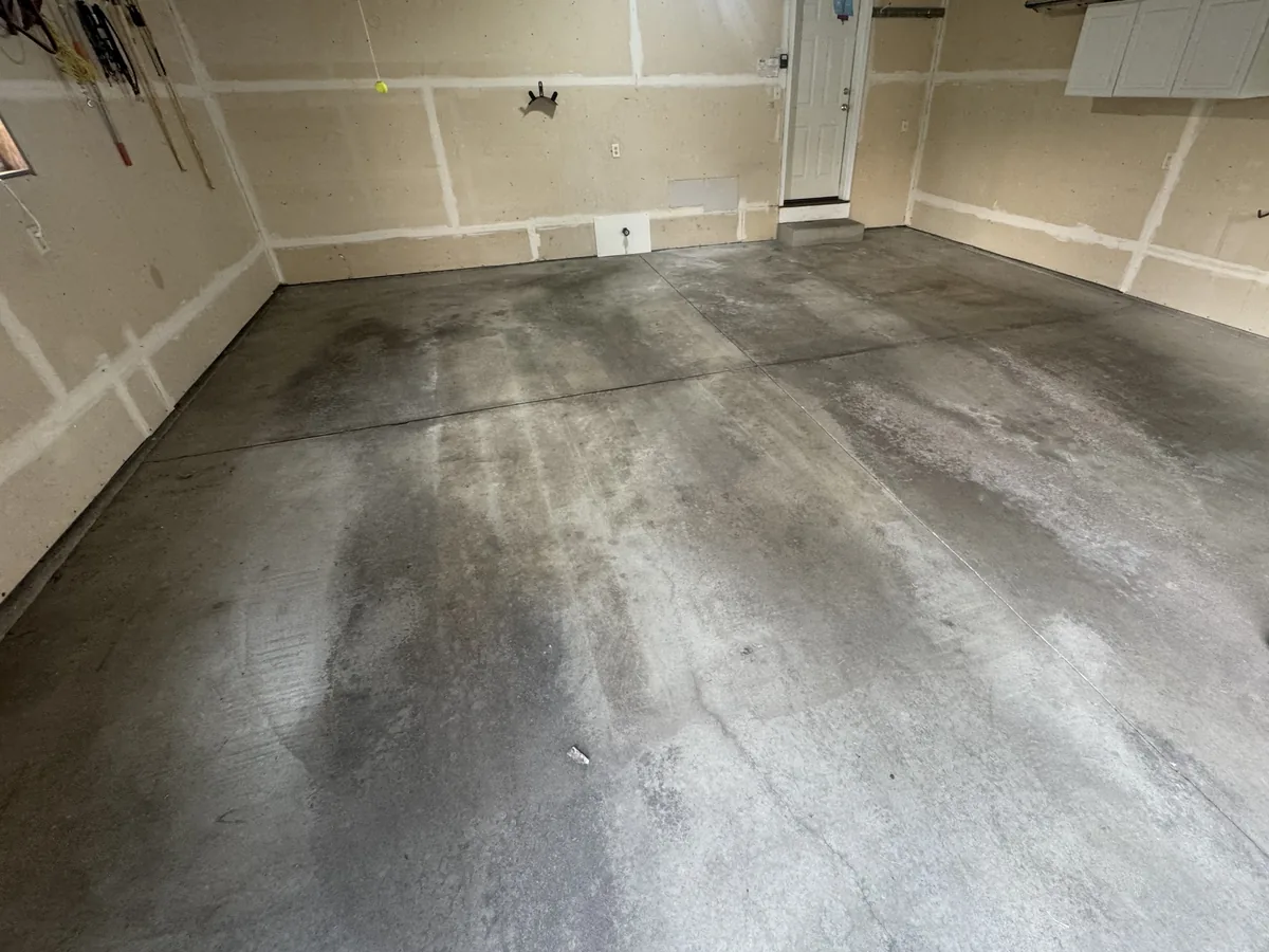 Garage slab with dark stains before coating