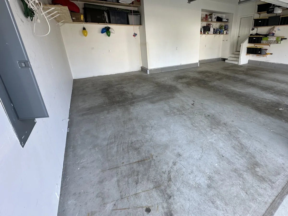 Stained and tire marked concrete garage floor before coating