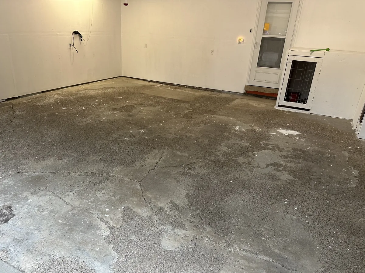 Garage slab with a worn old coating and cracks before the new coating