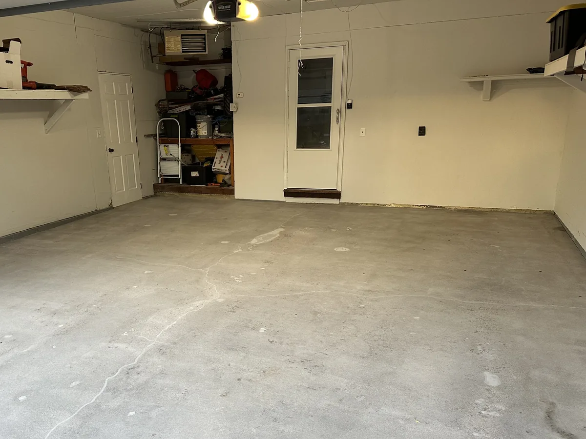 Bare concrete garage floor with a long crack before coating
