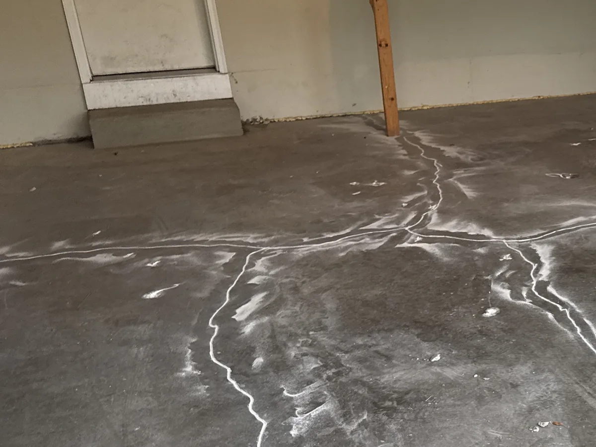 Cracks across a garage slab filled with repair material