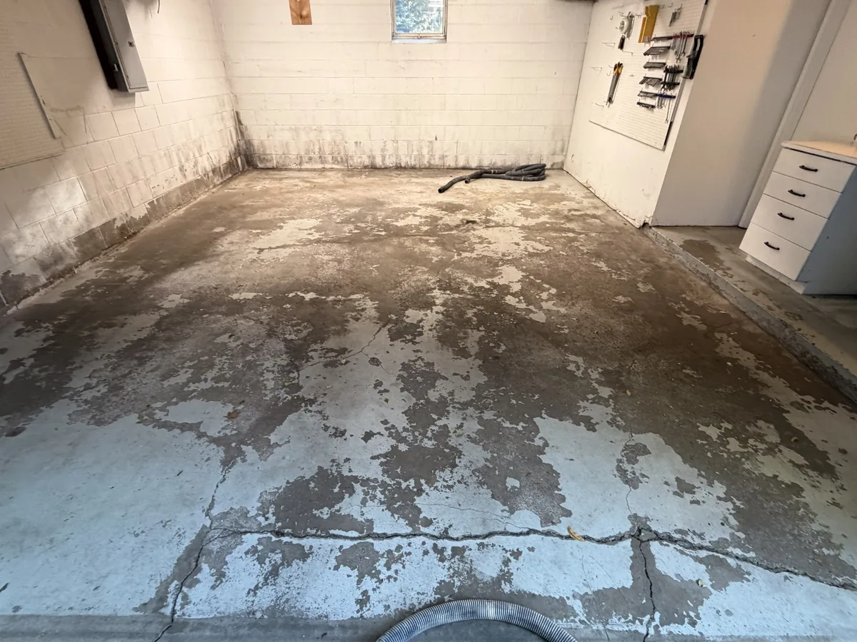Worn garage slab with peeling paint and cracked concrete