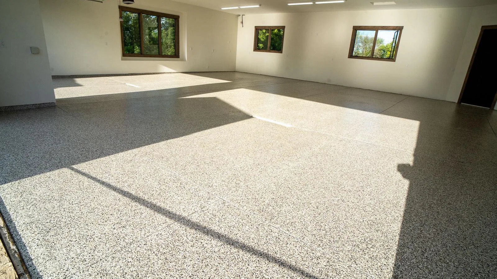 Bright garage with a light flake floor coating and sunlit windows