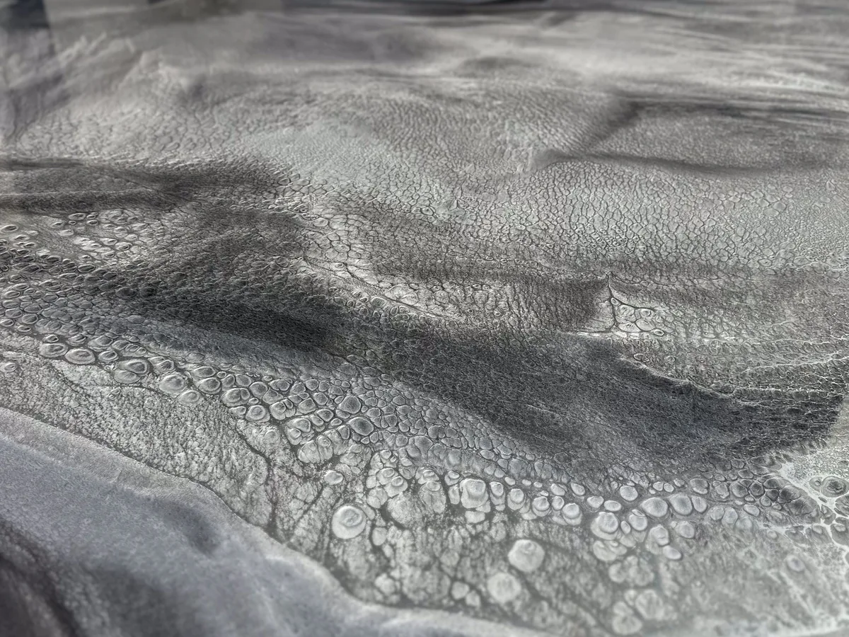 Close up of swirling gray and white metallic epoxy