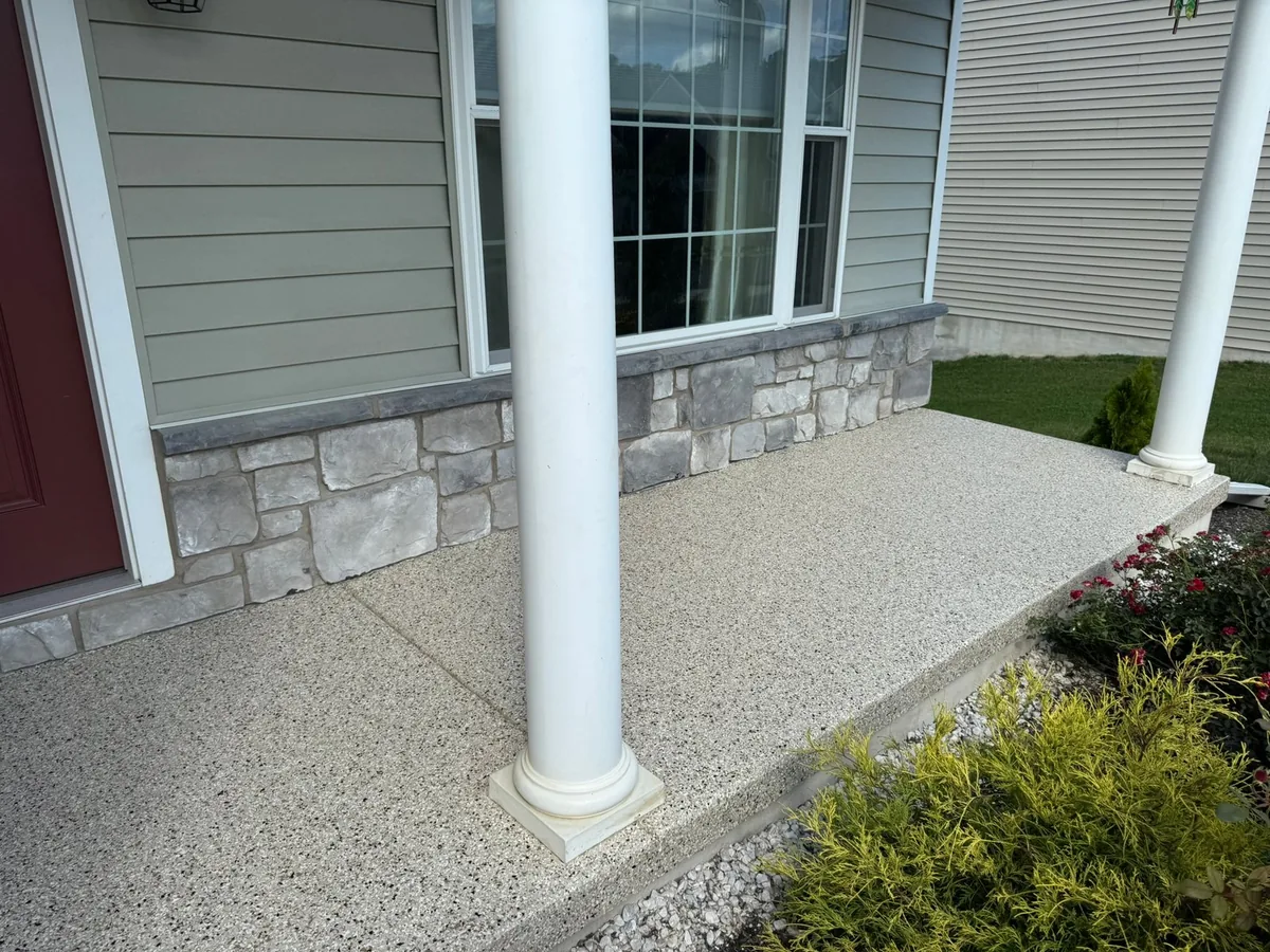 Flake coated concrete front porch with white columns
