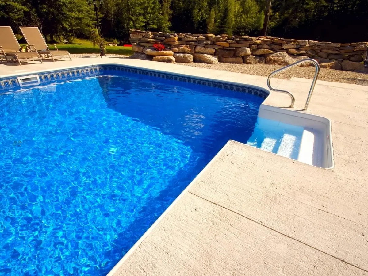 Light textured coating on a concrete pool deck beside an inground pool