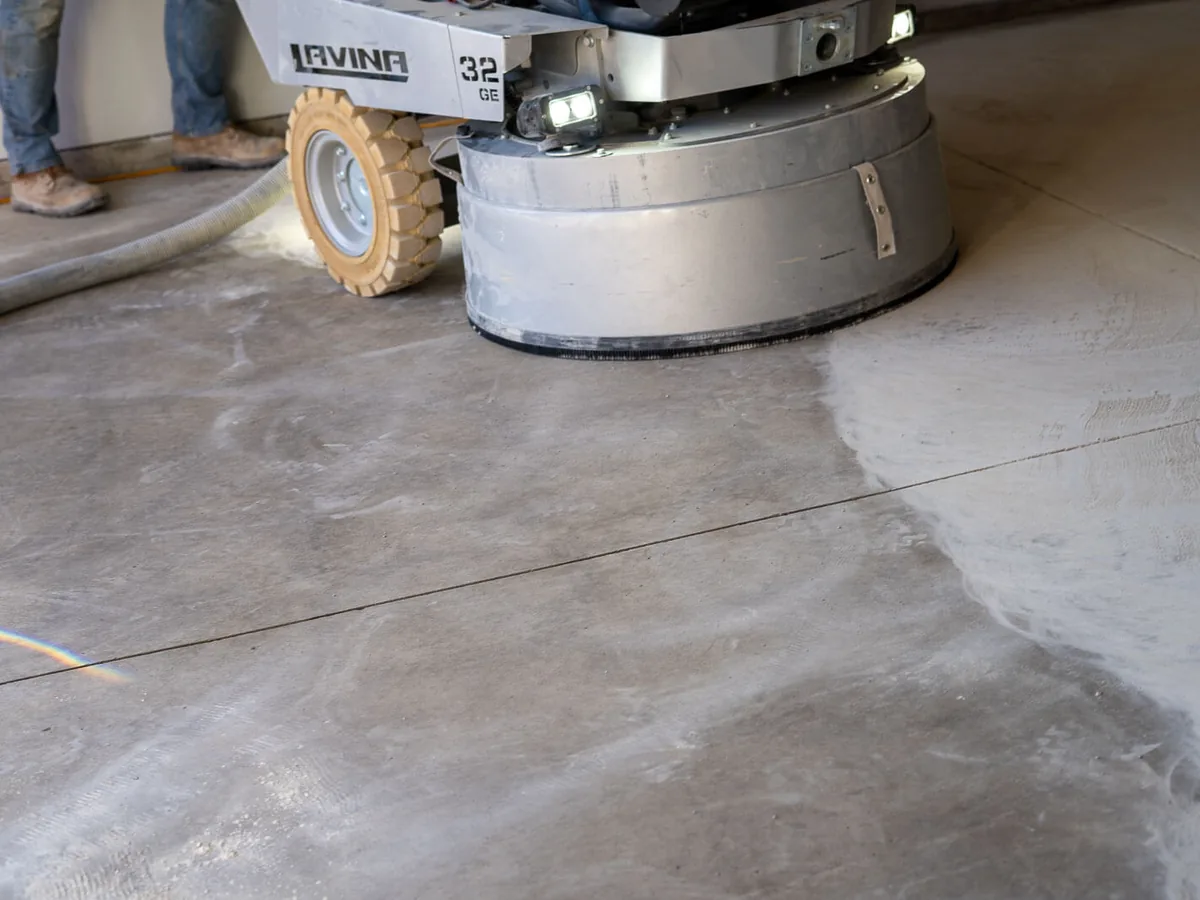 Diamond grinder cutting into a concrete slab, half ground and half raw
