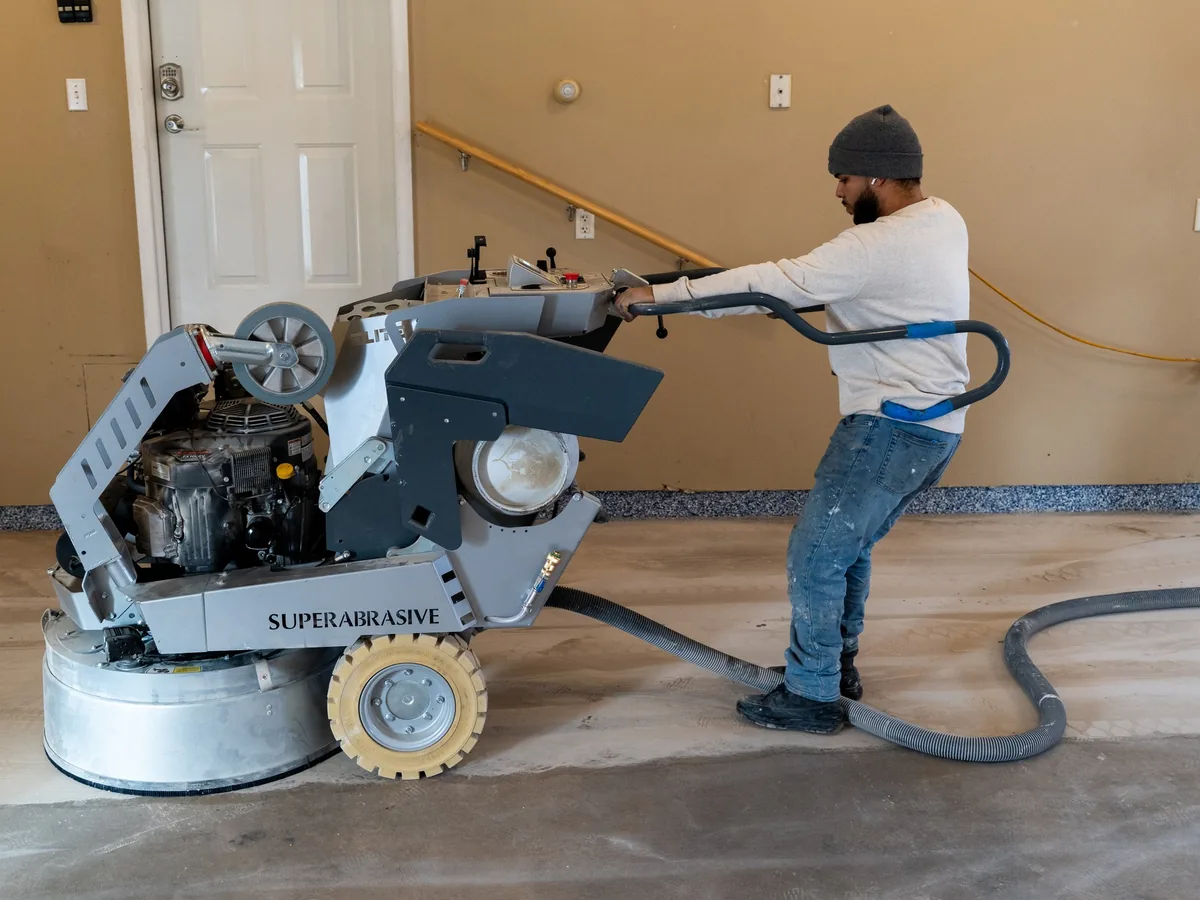 Slab Lab Coatings crew member grinding a garage floor before coating